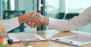 corretor e novo proprietário apertando as mãos ao fechar negócio
